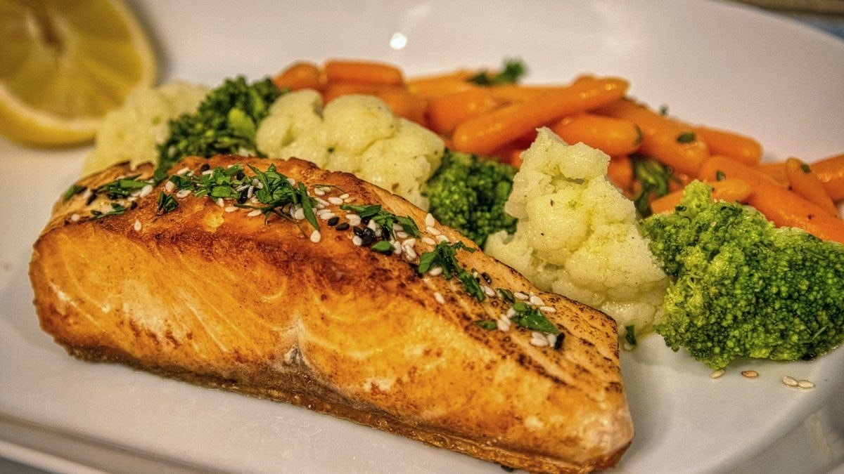 Baked salmon with steamed vegetables on a plate – oily fish is the most significant natural source of vitamin D